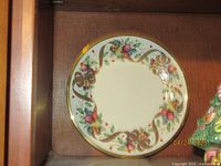Front view of Lenox Holiday Tartan plate showing colorful ribbons, bows, berries, and gold rim design.