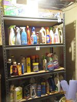 Full view of metal shelving unit with assorted cleaning products including Lysol, Windex, and assorted sprays and bottles.