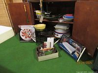 Overview shot of kitchenware items including boxed serving tray, cookware, pans, and utensils