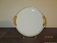 Full view of the Limoges porcelain platter showing white base with gold decorative handles and border.