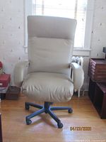 Front view of beige leather office chair showing cushioned seat, high backrest, padded armrests, and black wheeled base.