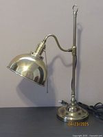 Side view of vintage brass table lamp with dome head and pull chain switch.