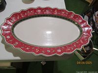 Oval platter showing scalloped edge red border with festive icons and plain cream center