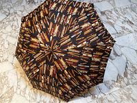 Top-down view of full-size umbrella opened showing all-over cigar print pattern.