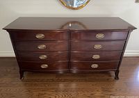Front view of mahogany dresser with eight drawers and brass pulls