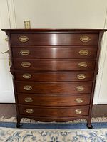 Front view of chest showing six convex drawers and brass hardware
