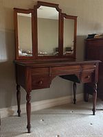Front view of walnut vanity table with triple-panel mirror attached