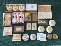 Top view of assorted luxury soaps laid out showing variety including boxed, wrapped, and loose soaps with different shapes and brands.
