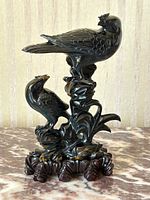 Front view of two falcon figures carved in blue tiger eye quartz on wooden base