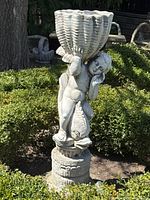 Front view of the full statue showing cherub holding planter bowl