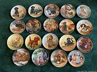 Full view of all 20 decorative dog plates arranged in rows, showing variety of breeds and scenes.
