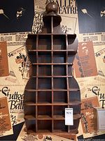 Full front view of corset-shaped cabinet showing entire silhouette and cubby layout