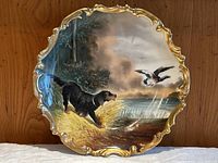 Full frontal view of scalloped gilt-edged plate on wood background