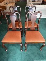 Four chairs arranged on green carpet showing overall set
