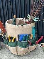 Close-up of canvas tool organizer with hand tools and decorative stakes