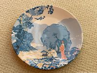 Full view of the porcelain plate with nature scene and figures, showing overall design and condition.