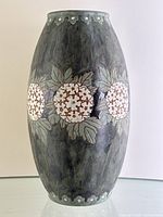 Full front view of vase on glass surface against white background