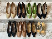 Top-view of all seven pairs of shoes showing various styles and colors arranged in two rows on marble floor.