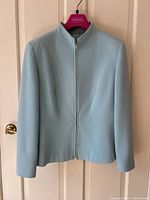 Full frontal view of the robin’s egg blue jacket hanging on a door