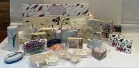 Photo displaying a large assortment of different luxury soaps and multiple scented drawer liner boxes, showcasing shapes, packaging, and colors.