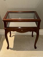 Front view of mahogany display table with glass top closed