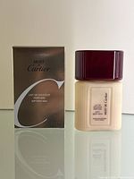 Photo showing original box and bottle of Must de Cartier Soft Body Milk 100ml, front view