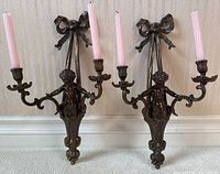 Front view of both sconces side by side showing overall design, cherub figures and candle arms