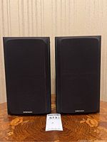 Front view of two Pioneer S-P410 speakers with black grille covers in place.