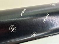 Close-up showing the black wrapping paper with white Chanel logos and word marks.