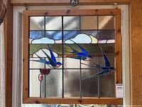 Full front view of square stained glass window panel in natural wood frame