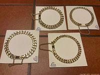 Four new old stock faux gold heavy chain link bracelets attached to Luxor cardboard