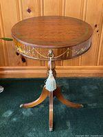 Full front view of round drum table showing tabletop, painted apron and pedestal base