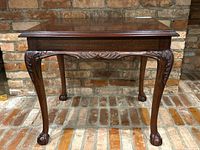 Front view of the vintage solid wood Lane end table showing claw feet and carved apron details.