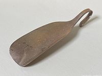 Angled view showing full length and curved hook handle of the shoe horn