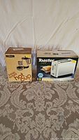 Photo of the boxed retro 6 cup coffee maker and boxed 2 slice toaster