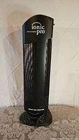 Front view of black Ionic Pro air purifier showing branding and vertical vent slats.