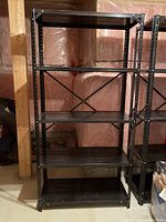 Single black metal shelving unit with 5 shelves, front view showing shelf surfaces and cross brace back support.