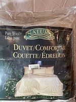 Photo of the wool duvet/comforter packaging front showing 'Natural Sleep Source' brand, 'Pure Wool', and 'Duvet/Comforter' labeling.