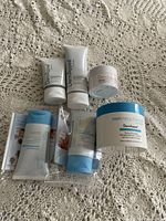 Photo showing all six DermAppeal by Skinn skincare products arranged on fabric surface.