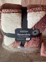 Photo of Berkshire reversible full blanket, dusty rose color with white sherpa fleece on reverse side, new in packaging with label visible.
