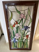 Front view of the rectangular wooden framed panel with colored resin artwork showing iris flowers and leaves against a textured clear background.