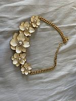 Vintage Joan Rivers white floral necklace with pearl and crystal accents, shown fully with adjustable gold tone chain.