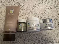 Four Kalaya products arranged on a crocheted fabric surface, showing front labels and packaging.