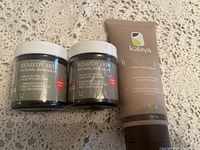 Two jars of Remedy Skin Natural Skin Salve and one tube of Kalaya Relyour Foot Treatment arranged on a crochet fabric background.