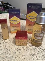 Photo showing all five L’Occitane products including the Immortelle Reset Oil-in-Serum boxes and Almond Shower Oil bottle