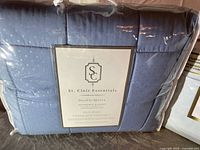 Packaged St Clair Essentials blanket in light blue, double/queen size, reversible polyester material with quilted design.