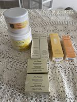 Lot of M.Asam skin care items including jars and boxed items on lace tablecloth.