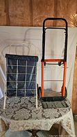 Photo showing the moving dolly and two wheeled cart side by side on a table with patterned cloth