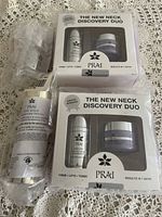 Photo of two boxed sets of Prai The New Neck Discovery Duo and one individual bottle of Prai 24K Gold Elixir skin concentrate.