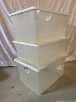 Stack of three clear Rubbermaid storage bins with white lids, two are HiTop 16.5 US gallon size.